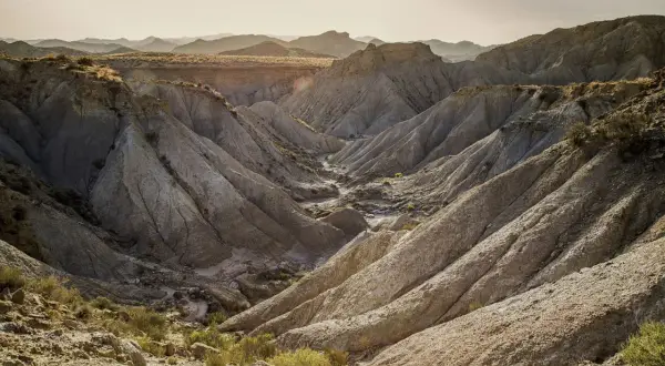Paisaje erosionado en el desierto de Tabernas que ver. Barrancos y montañas de tierra arcillosa bajo un cielo claro.