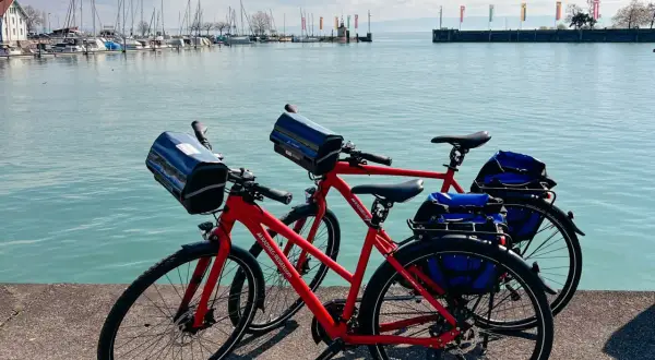 Zwei rote Fahrräder stehen am Ufer des Bodensees in Friedrichshafen, bereit für eine Tour.
