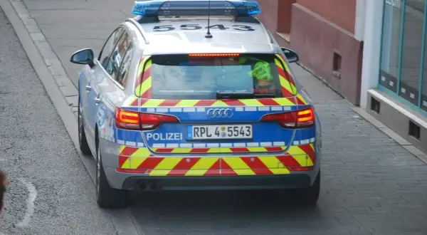 Niemiecki radiowóz z niebieskimi światłami i odblaskowymi pasami. Może wystawić mandaty w Niemczech.