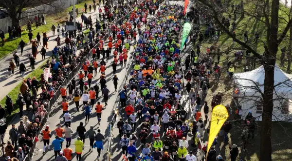 Tłum biegaczy na trasie maratonu, widziany z góry.