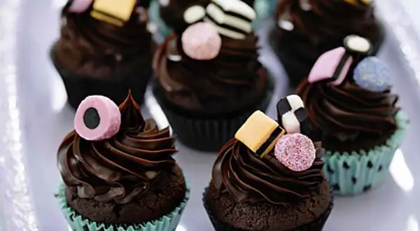 Chokladmuffins med chokladfrosting och godisdekorationer. Ett roligt recept på kakor för barnkalas.