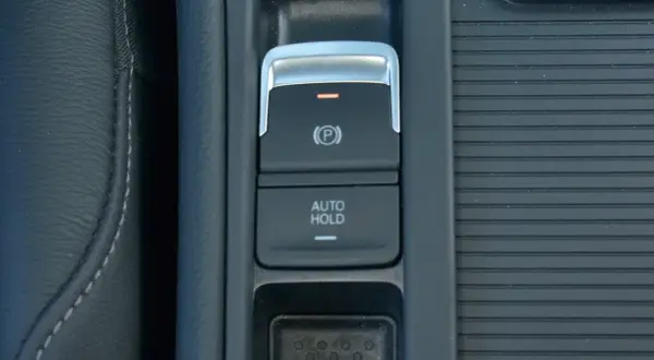 Przycisk auto hold w samochodzie, obok hamulca ręcznego.