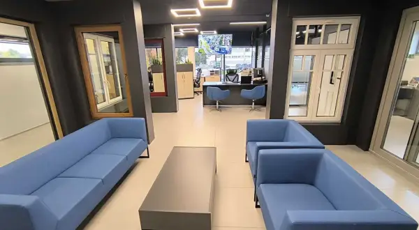 Nowoczesne wnętrze salonu okien i drzwi z niebieskimi sofami i stolikiem kawowym.