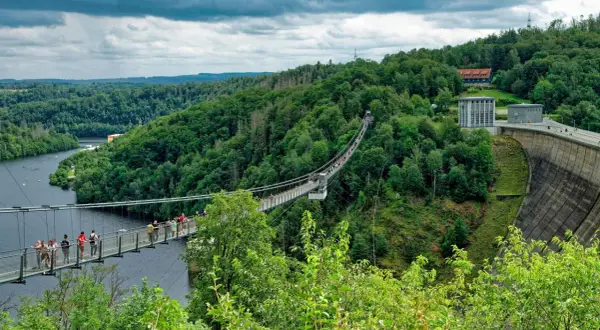 Hängebrücke über die Rappbodetalsperre, ein beliebtes Ausflugsziel im Harz. Menschen spazieren über die Brücke, umgeben von grünen Wäldern.