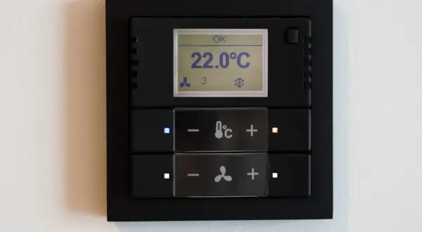 Panel klimatyzacji hotelowej z wyświetlaczem temperatury 22°C i przyciskami sterowania.