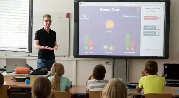 Nauczyciel prowadzi zajęcia, które mogą być częścią przygotowania pedagogicznego dla psychologów. Uczniowie uczestniczą w interaktywnej lekcji.
