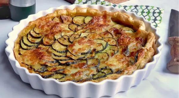 Tarte dorée aux courgettes et mozzarella, prête à être dégustée.