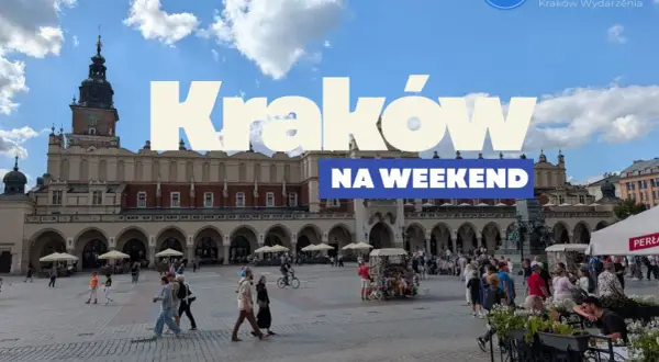 Tłum ludzi spaceruje po Rynku Głównym w Krakowie, ciesząc się piękną pogodą. Widać Sukiennice i wieżę Ratuszową.