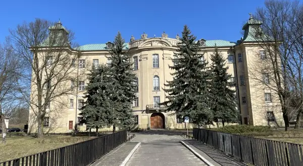 Pałac w Osiecznej, otoczony drzewami, zaprasza do odkrywania jego historii i uroków.