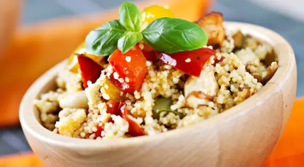 Ciotola di couscous con verdure miste e basilico, un piatto ideale per lo svezzamento a 6 mesi.