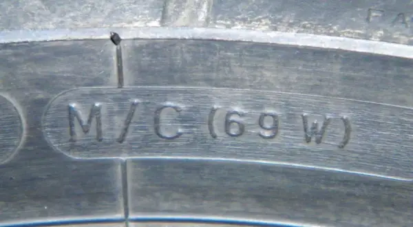 Napis "M/C (69 W)" wytłoczony na oponie motocyklowej.