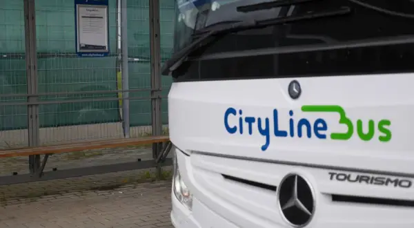 Autobus CityLineBus czeka na pasażerów na przystanku. Może to być podróż z Kielc na lotnisko w Katowicach.