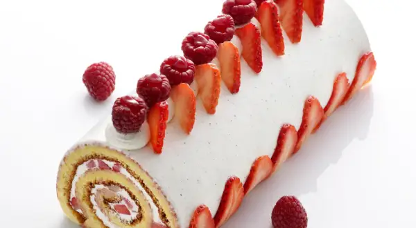 Un délicieux roulé fraise mascarpone, orné de fruits rouges frais et de fines tranches de fraises, invite à la gourmandise.