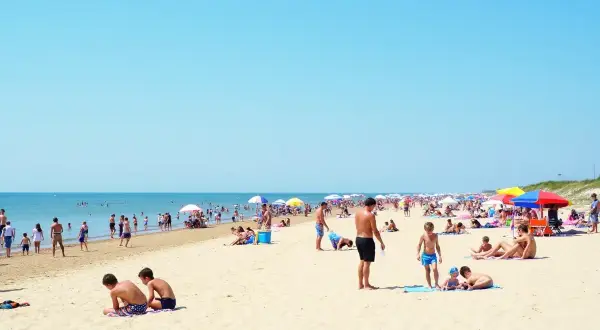 Tłum ludzi na plaży, idealne miejsce na wakacje. Gdzie najbliżej nad morze z Warszawy? Tutaj!