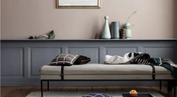 Ein Tagesbett mit Kissen und Decken vor einer Wand in einem sanften Rosaton. Welche Farbe wirkt beruhigend? Dieses Rosé schafft eine friedliche Atmosphäre.