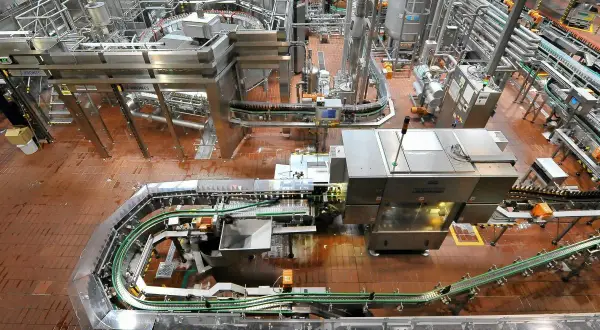 Widok z góry na linię produkcyjną browaru z butelkami na taśmociągach.