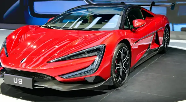Czerwony supersamochód BYD U9 z czarnym dachem i spoilerem, prezentowany na wystawie.