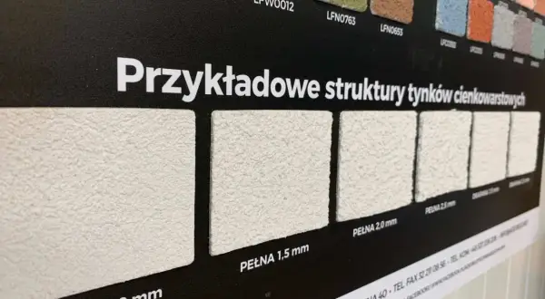 Próbki tynków elewacyjnych o różnych fakturach i grubościach ziarna.