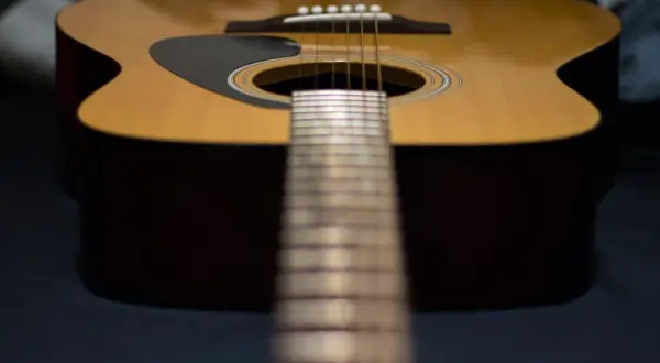 Nahaufnahme einer Akustikgitarre mit Fokus auf die Saitenlage.