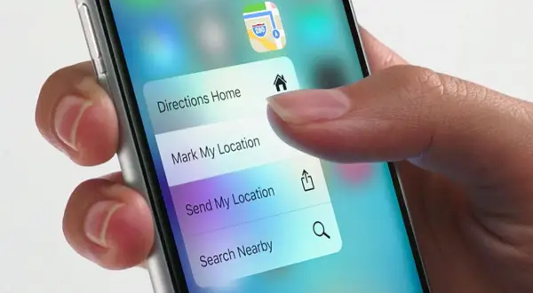 Dłoń naciska na ekran telefonu, aktywując menu z opcjami nawigacji. Funkcja 3D Touch pozwala na szybki dostęp do "Directions Home", "Mark My Location" i innych.