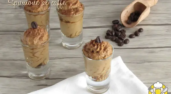 Delizioso spumone al caffè in bicchierini, guarnito con chicchi di caffè e cacao. Perfetto per un dolce momento.