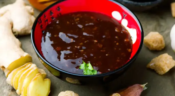 Sos teriyaki przepis: aromatyczny sos w miseczce, obok imbir, czosnek i cukier. Idealny do dań azjatyckich.