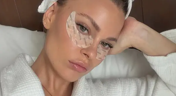 Mujer con parches en los ojos, luciendo relajada. Quizás se pregunta: ¿vitamina k para qué sirve?