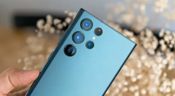 Dłoń trzyma niebieski Samsung z modułem aparatów. To prawdziwy **expert raw samsung** do fotografii.