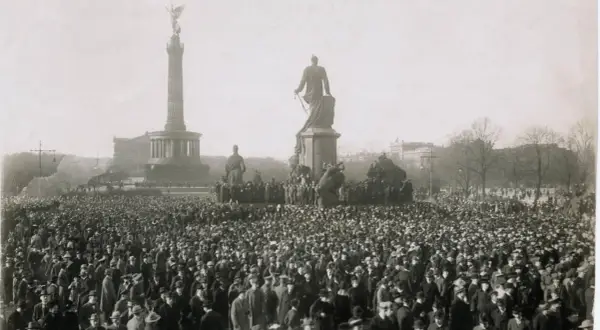 Menschenmenge vor dem Siegessäule-Denkmal in Berlin, ein Symbol der revolutionären Stimmung der Revolution 1918.