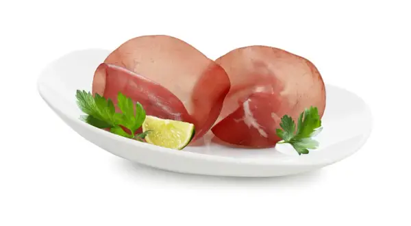 Fette di bresaola su piatto bianco con prezzemolo e lime. Ottima per un pasto leggero, scopri le calorie bresaola.