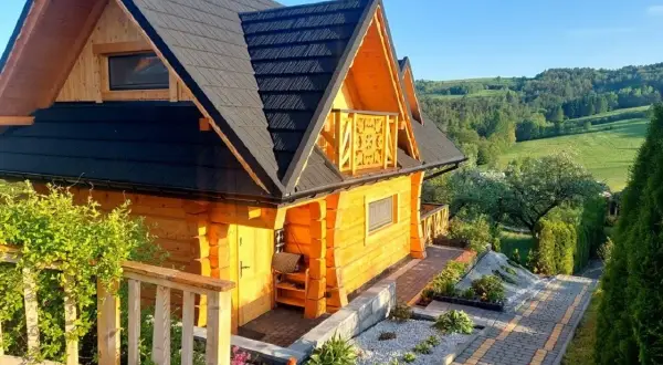 Drewniany domek z balkonem i pięknym widokiem na wzgórza. Idealne miejsce na agroturystykę w Małopolsce.