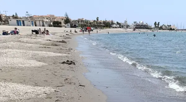 Gente disfrutando de un día soleado en la playa de Almerimar. Las opiniones sobre este lugar son muy positivas, ideal para relajarse.