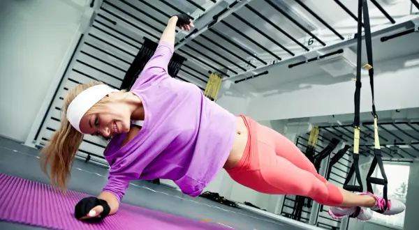 Frau macht seitlichen Unterarmstütz auf Matte, ein Beispiel für funktionelles Training.