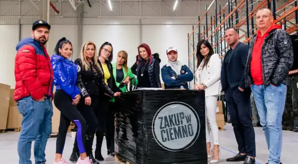 Grupa osób pozuje przy palecie z napisem "zakup w ciemno".