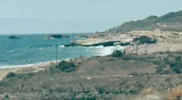 Vista de la playa de los Genoveses, con el mar azul y las colinas. Un lugar ideal para disfrutar y comer algo.