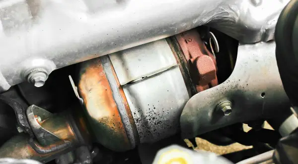 Système d'échappement de voiture, avec un catalyseur rouillé. La suppression du FAP peut permettre un gain de puissance.