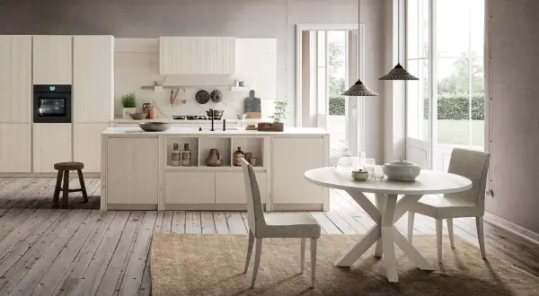 Cucina chiara con isola centrale e tavolo rotondo. Ecco come abbinare il tavolo alla cucina per un look armonioso.