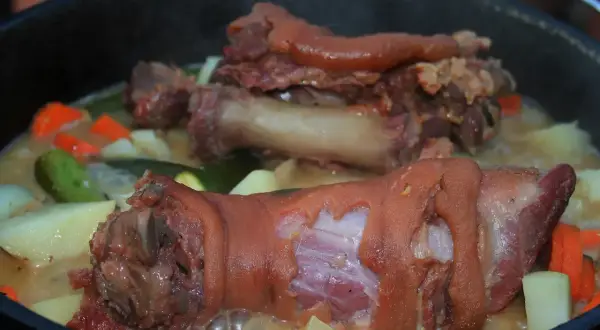 Gotuje się pyszna zupa na golonce wieprzowej z ziemniakami, marchewką i cukinią. Aromatyczny bulion kusi zapachem.
