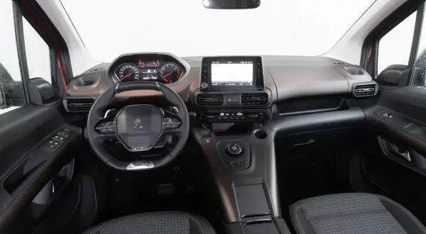 Interni Peugeot Rifter: volante, cruscotto digitale, schermo touchscreen e sedili in tessuto.