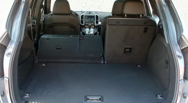 Maletero de un Porsche Cayenne, mostrando su amplitud y los asientos traseros abatibles. Ideal para conocer las porsche cayenne medidas de carga.