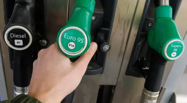 Dłoń wybiera dystrybutor z napisem "Euro 95 E10". Zastanawiasz się, jakie paliwo do samochodu? Obok widać Diesel i Super+ 98.