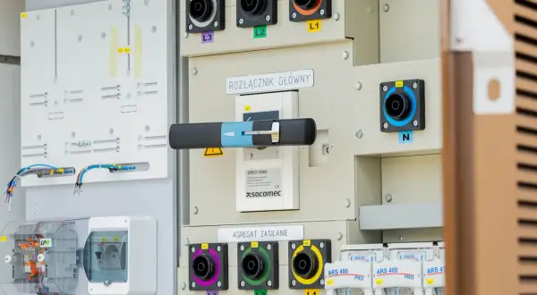 Panel sterowania z rozłącznikiem głównym i agregatami synchronizacji i zasilania. Widoczne złącza L1, L2, L3, N oraz bezpieczniki. System wykorzystuje izolację SF6.