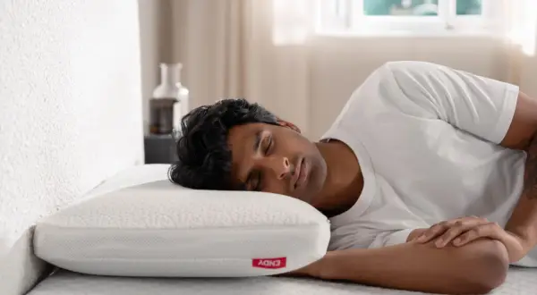 A man sleeps soundly on a white pillow, enjoying a peaceful rest. This image reassures that bamboo pillows are not toxic.