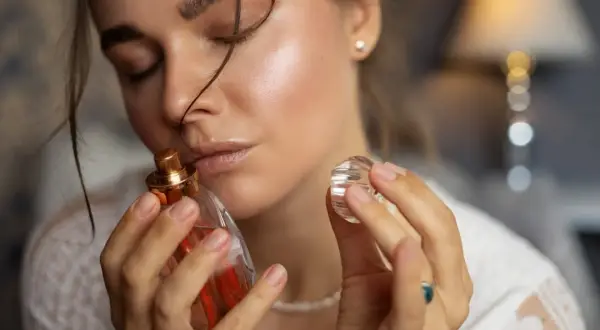 Kobieta wącha perfumy. Czy refill perfumy to sposób na ponowne użycie ulubionego zapachu?