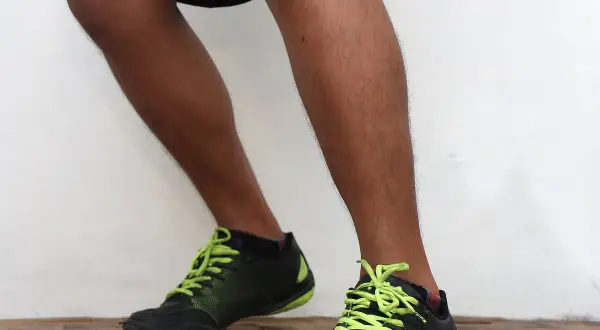A boxer demonstrates the correct orthodox boxing stance, with feet planted and knees slightly bent, ready to move.