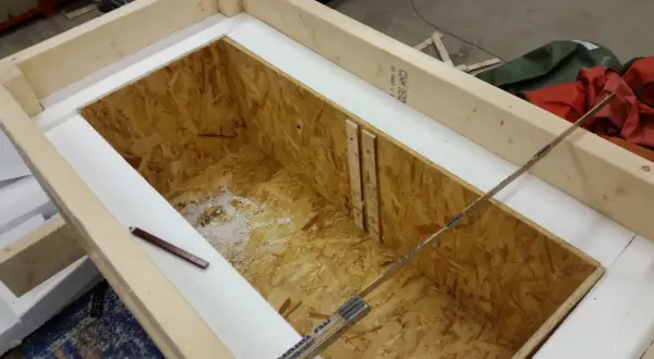 Wooden frame with OSB interior, insulated with white foam. A pencil and ruler are visible.