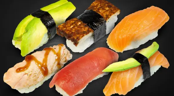 Sechs Nigiri-Sushi-Stücke: Lachs, Thunfisch, Avocado und Tamagoyaki. Was ist Nigiri? Sushi mit Reis und Belag, oft mit Nori umwickelt.