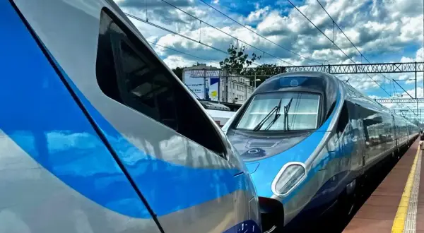 Dwa pociągi PKP Intercity stojące obok siebie na peronie. Jeden z nich to Pendolino, gotowe do podróży z Kołobrzegu do Krakowa Głównego.