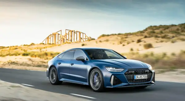 Niebieskie Audi RS7 pędzi po pustynnej drodze. Sprawdź aktualną audi rs7 cena i poczuj moc!