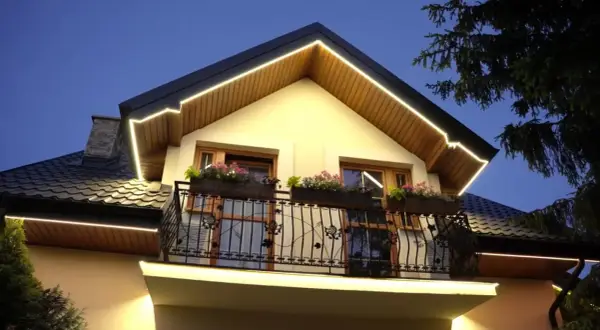 Eleganckie oświetlenie podbitki podkreśla architekturę domu, tworząc przytulną atmosferę wieczorem.